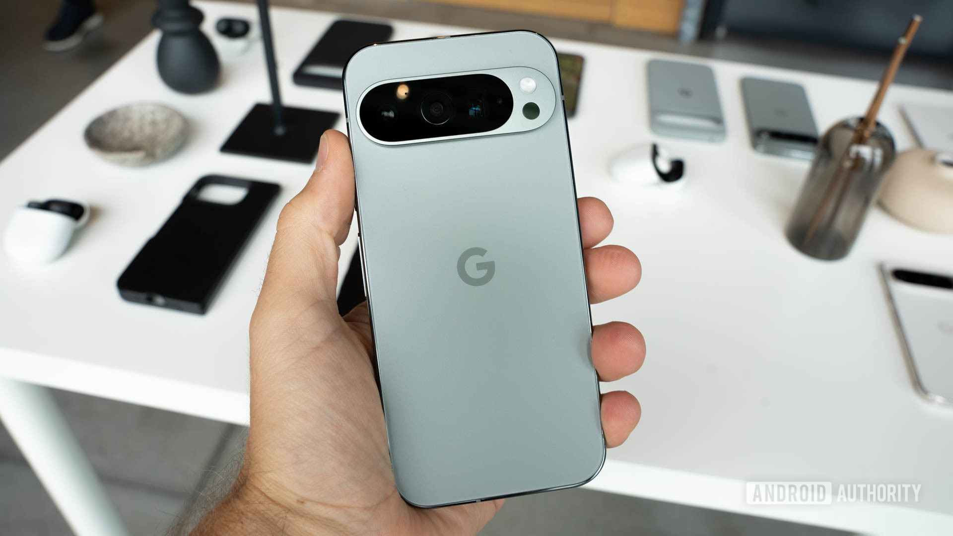 Google Pixel 9 Pro in Hazel color is held in the left hand of the viewer