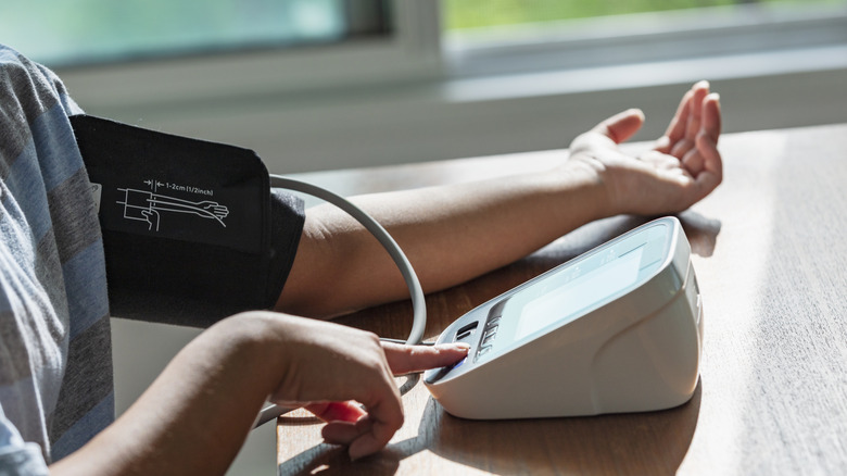 a person who measures his blood pressure using a cuff