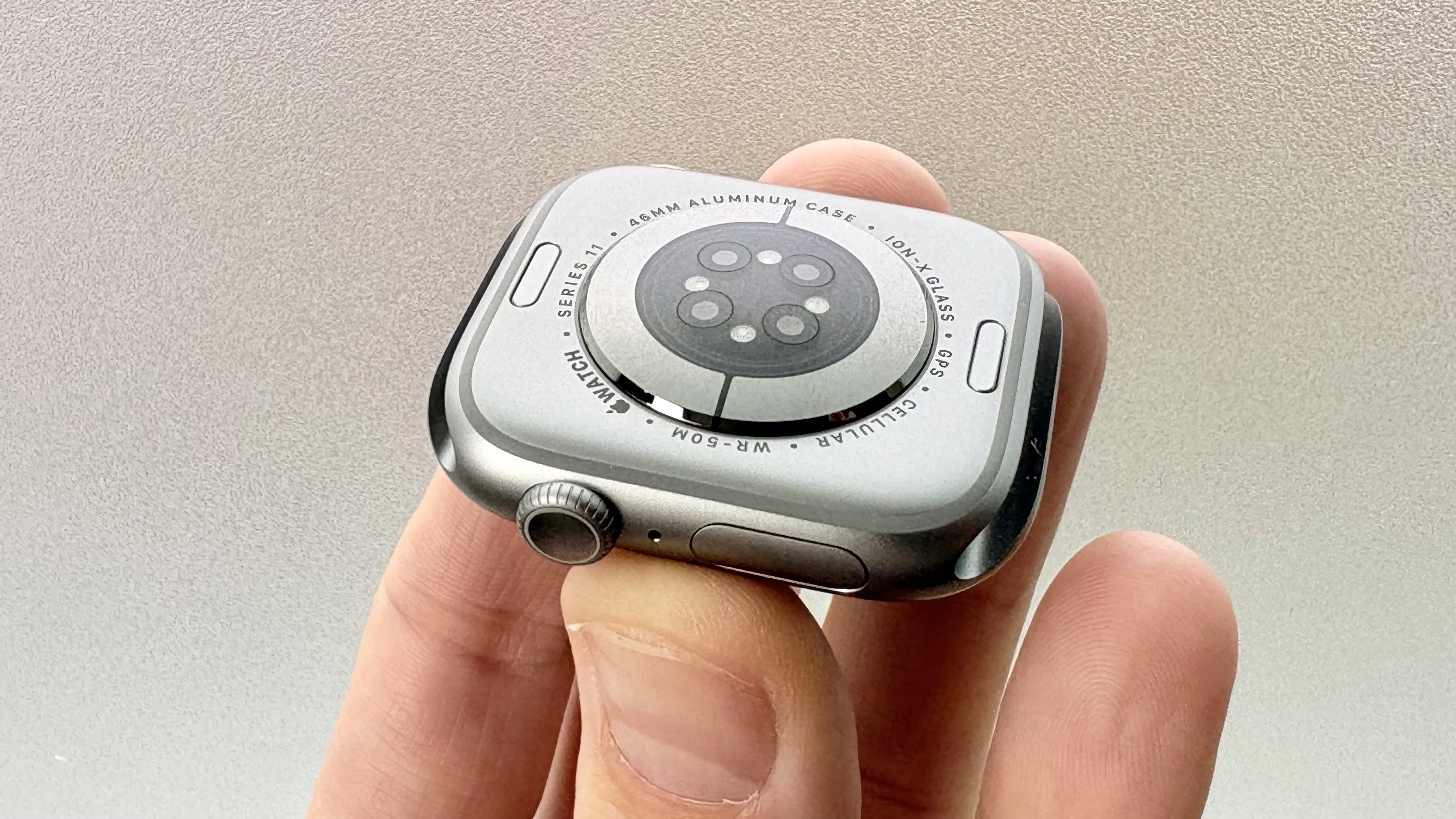 Next to the sensor cluster on the back of the Apple Watch Series 11